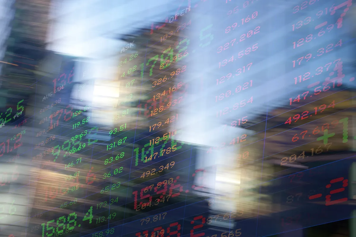 Motion-blurred financial stock ticker display showing market prices and numbers in red and green